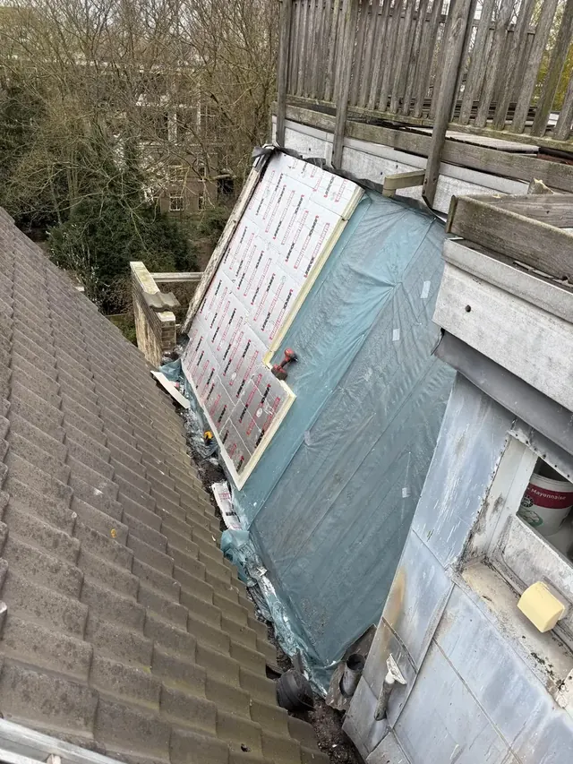 Isolatie in de dakopbouw — Zichtbare isolatie en onderliggende lagen tijdens het vernieuwen van het dak.